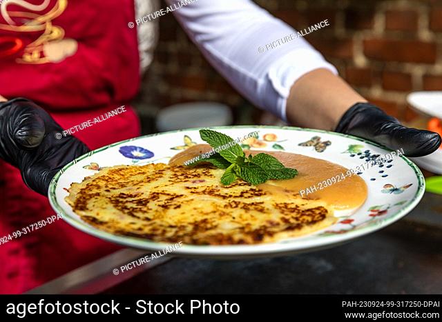24 September 2023, Brandenburg, Lübbenau/Ot Lehde: A Spreewald potato pancake with applesauce lies on a plate in the Spreewald village of Lehde