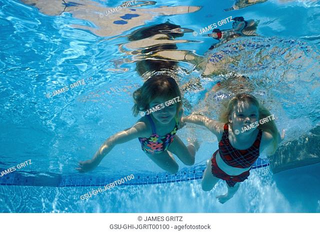 Two Girls Swimming Underwater in Pool