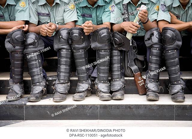Police force ; policemen sitting on staircase wearing black shoes ; Dhaka ;  Bangladesh
