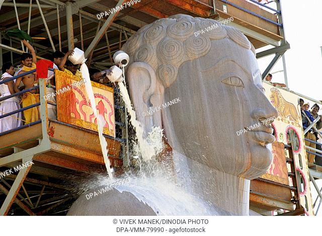 Jain Devotees pouring milk on the head of 58.8 feet monolithic Statue of jain saint Gomateshwara (Lord Bahubali) in Mahamastakabhisheka (head anointing...