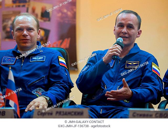 Expedition 37 Russian Flight Engineer Sergey Ryazanskiy, right, answers a reporter's question at a press conference held at the Cosmonaut Hotel, on Sept