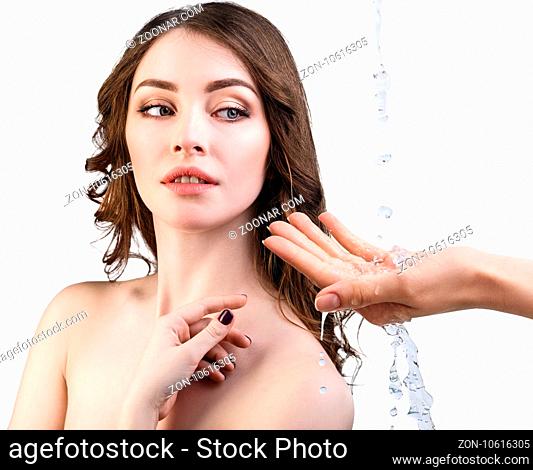 Beautiful woman face and splashes of water in hand. Cleansing and moisturizing concept