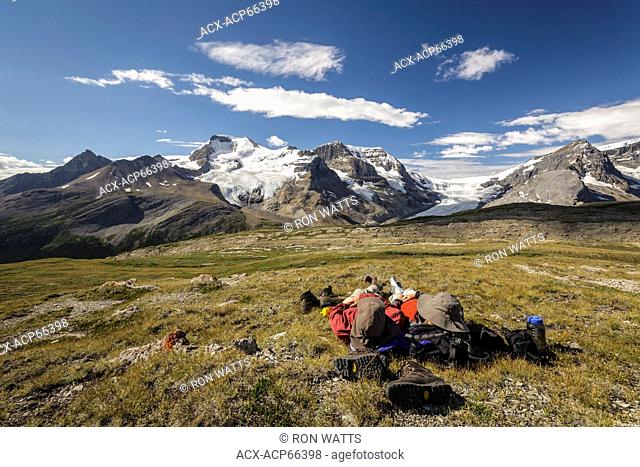 Two hikers relax overlooking Mount Athabasca from the summit of Wilcox Pass in Jasper National Park, Alberta, Canada. Model Released