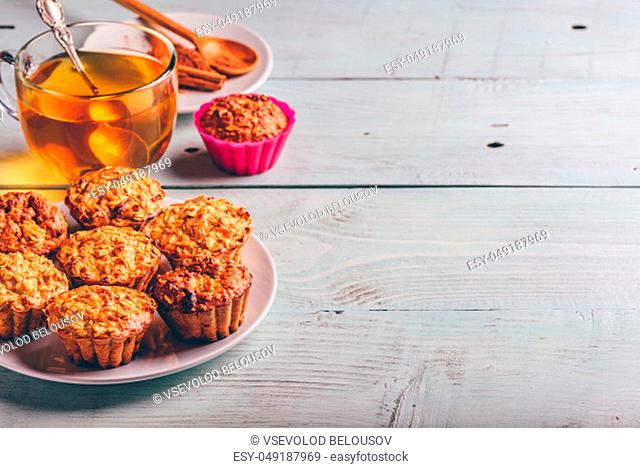 Healthy Dessert. Oatmeal muffins with cup of green tea over light wooden background. Copy Space