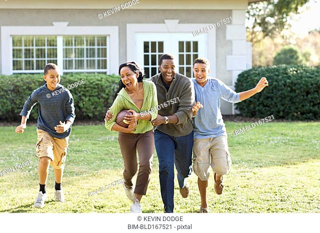 Family playing football in backyard