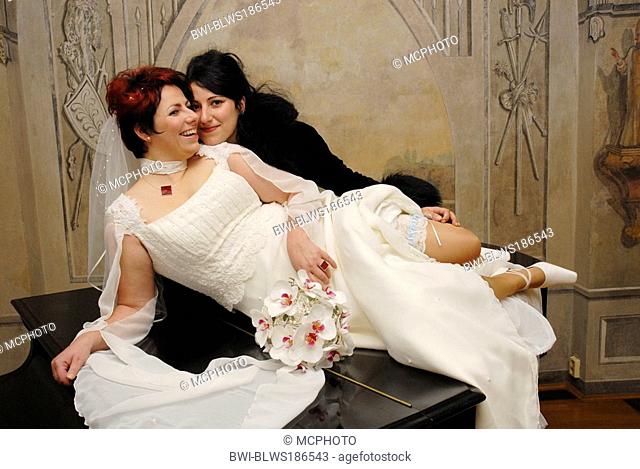 bride lying with her sister on grand piano