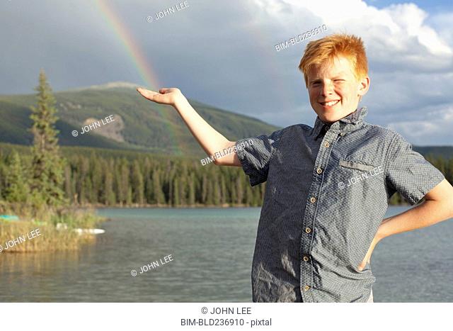 Caucasian boy posing at lake catching rainbow