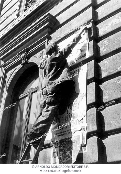 A man stacking a placard of the Italian Republican Party (PRI) onto an Italian Socialist Party (PSI) poster. 1953