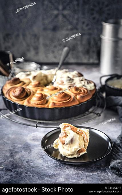 Cinnamon rolls, half covered with cream cheese frosting