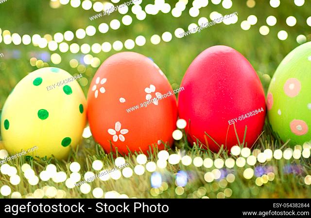 row of colored easter eggs on artificial grass