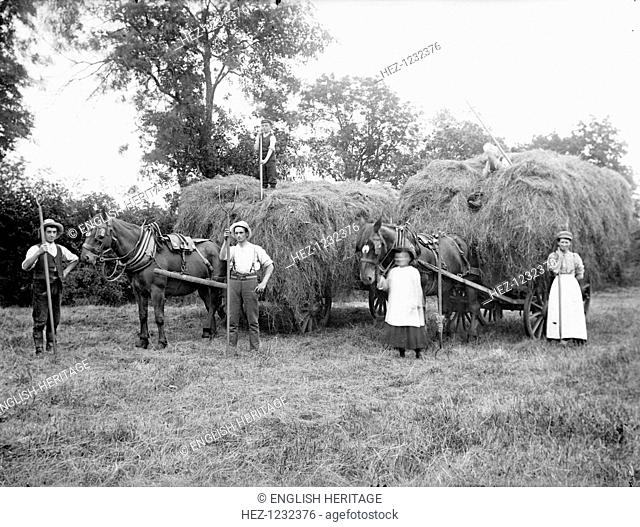 Agricultural workers pose next to loaded hay waggons near Hellidon, Northamptonshire, c1873-c1923