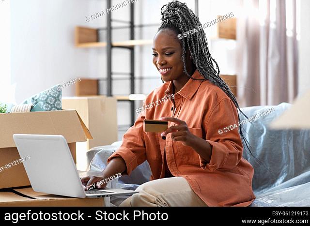 woman with laptop and credit card at new home