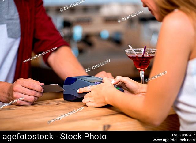 Beautiful Girl In White Dress Puts Pin Code In Card Machine. Paying For Coffee In Cafe