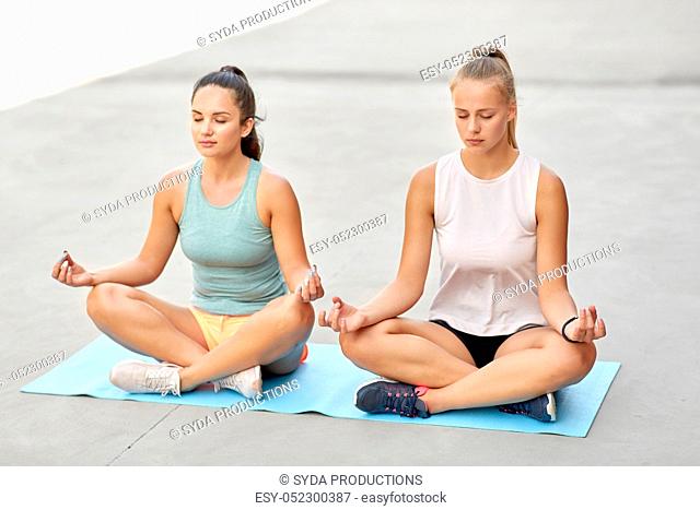 women doing yoga and meditating in lotus pose
