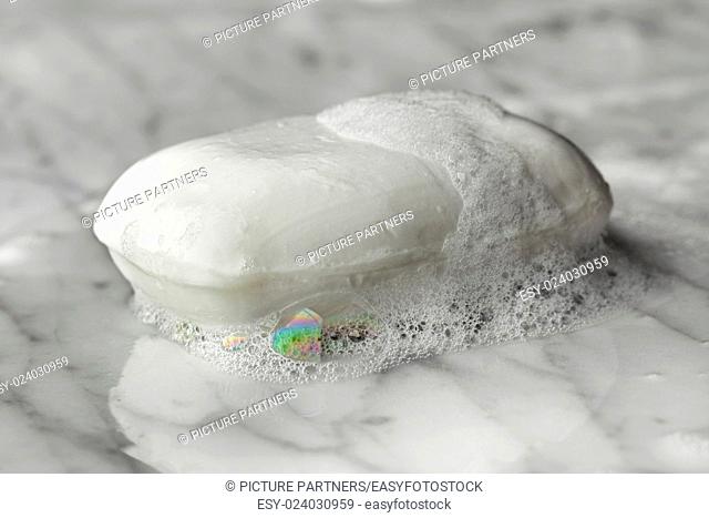Bar of wet white soap with foam