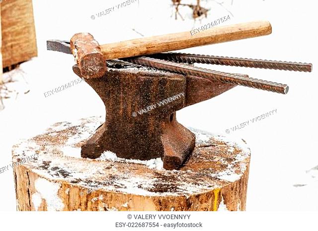 anvil with blacksmith tongs hammer in smithy