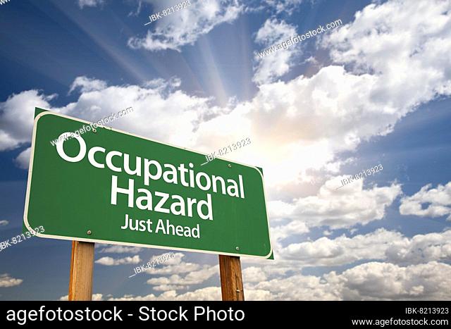 Occupational hazard green road sign with dramatic clouds and sky