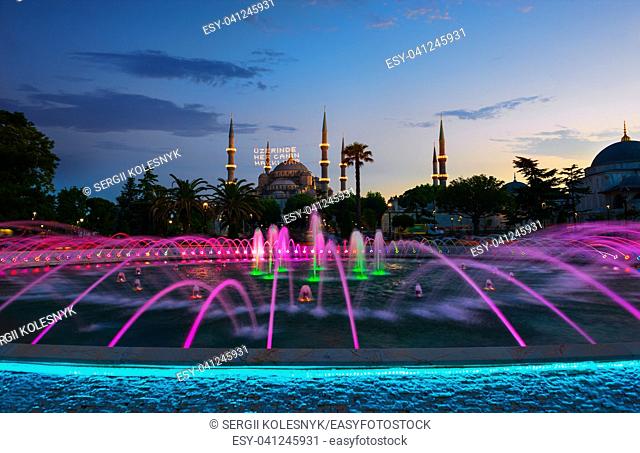 Blue Mosque illuminated at evening in Istanbul, Turkey. Inscription on a mosque is translated as On him is a soul of everyone