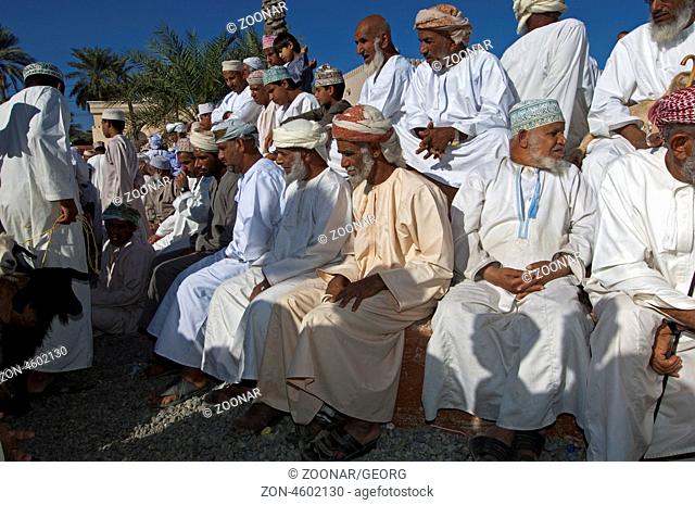Omanische Männer in Dishdash Nationaltracht auf dem Ziegenmarkt, Nizwa, Sultanat Oman / Omani men in traditional Dishdash garments at the goat market, Nizwa