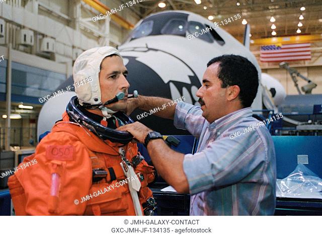 Astronaut John B. Herrington, STS-113 mission specialist, dons a training version of the full-pressure launch and entry suit prior to the start of a training...