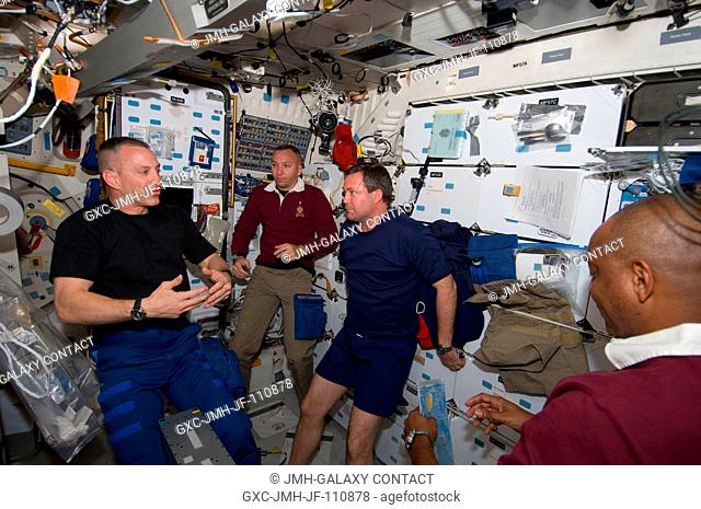 Astronaut Charles O. Hobaugh (left), STS-129 commander, briefs his crew on the middeck of Space Shuttle Atlantis during flight day two activities