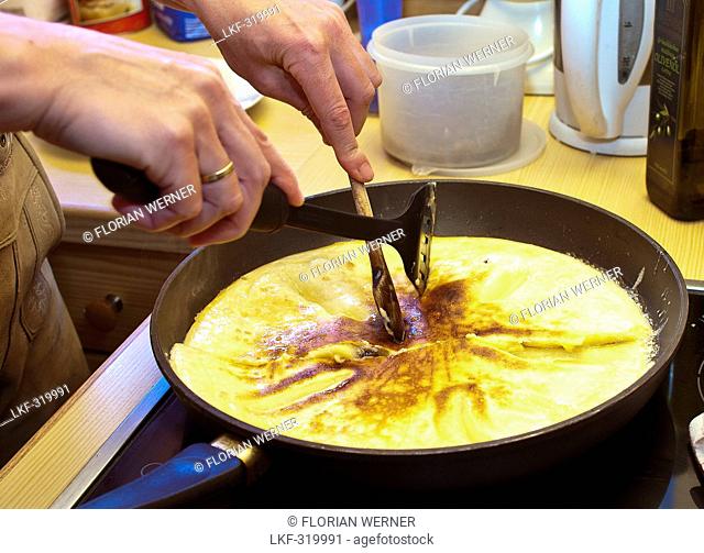 Cook cutting-up the sugared raisin pancake, Molterau alpine hut, Region of Hochkoenig, Salzburger Land, Austria