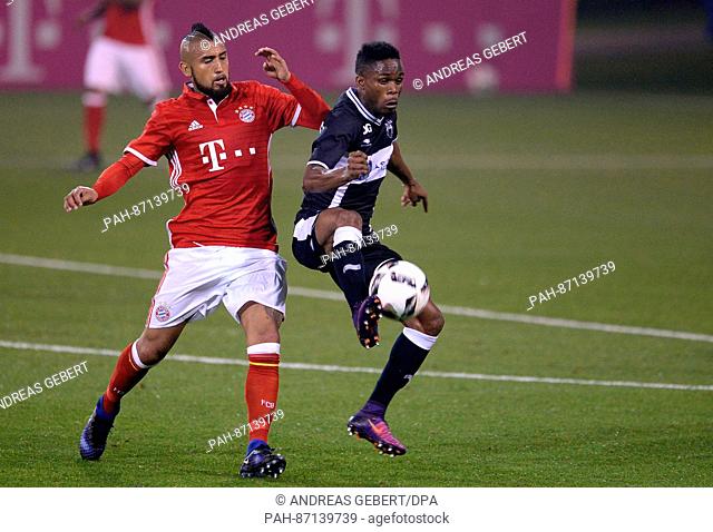 Bayern Munich's Arturo Vidal (l) and Jean Thierry Lazare of KAS Eupen vie for the ball during a friendly soccer match at the training camp in Doha, Qatar