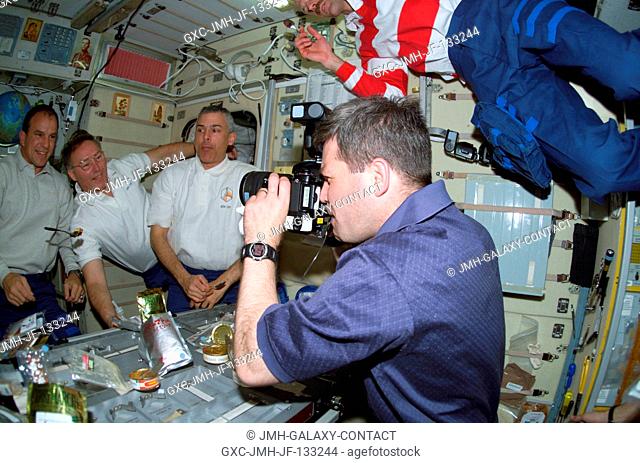 Astronaut Stephen N. Frick, STS-110 pilot, photographs crewmates in the Zvezda Service Module on the International Space Station (ISS)