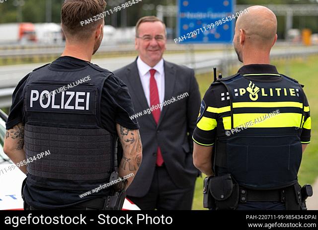 11 July 2022, Lower Saxony, Bad Bentheim: Lower Saxony's Interior Minister Boris Pistorius (SPD) talks with a German (l) and a Dutch (r) police officer from the...