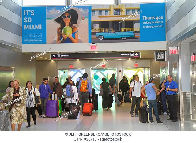Florida, Miami, International Airport, MIA, billboard, travelers, Hispanic, man, woman, luggage, terminal, concourse, gate area