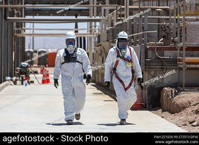 25 October 2022, Chile, Antofagasta: Workers walk in protective suits and masks through the lithium carbonate production plant of the Chilean company SQM