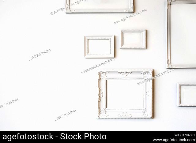 White various antique blank photo or picture frames on the white wall modern design, minimal interior design, copy space or space for text close up