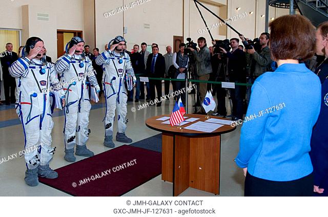 Expedition 31 backup crew members Kevin Ford, Oleg Novitskiy and Evgeny Tarelkin salute senior officials before their final qualification test in preparation...