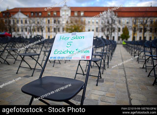 19 October 2022, Saxony-Anhalt, Magdeburg: ""Here sit five educators"" is written on a sign attached to a chair on the Domplatz