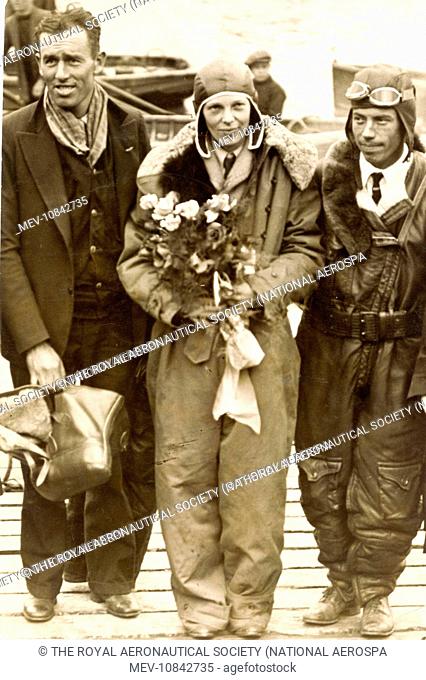 Amelia Earhart, centre; Wilmer Stultz, pilot, right; and Louis Gordon, co-pilot. Burry Port, Wales, after their non-stop flight from Newfoundland starting on 17...