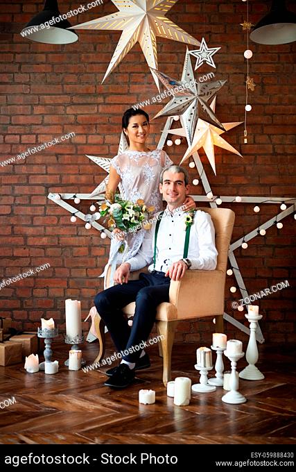 Cheerful married couple near the brick wall decorated with the stars