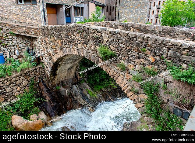 ESCALDES-ENGORDANY, ANDORRA - 2020 juny 8: River Madriu on La Tosca Bridge and houses view in a snowfall day in small town Escaldes-Engordany in Andorra on juny...