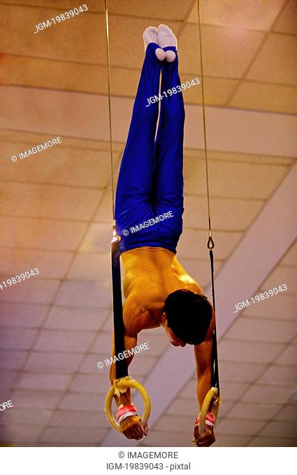 Young man practicing gymnastics on the gymnastic rings