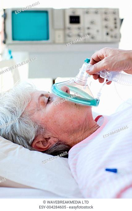 Senior patient receiving oxygen mask