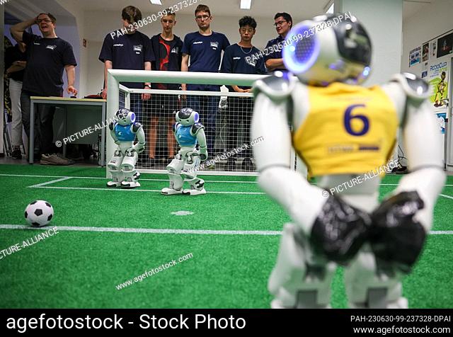 PRODUCTION - 28 June 2023, Saxony, Leipzig: Nao robots play soccer during a training game in a laboratory at the Leipzig University of Applied Sciences (HTWK)