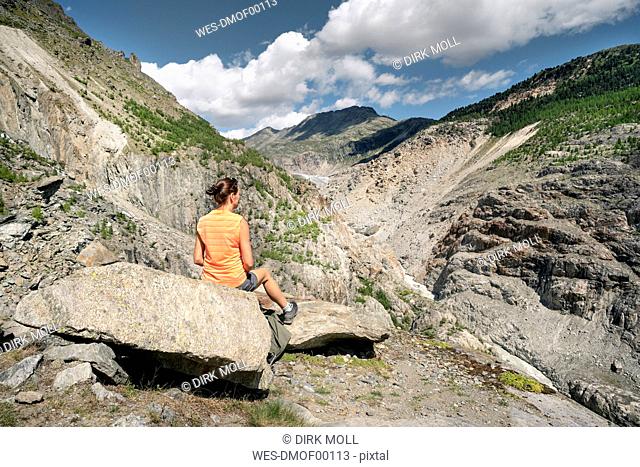 Switzerland, Valais, woman resting during a hiking trip in the mountains at Aletsch Glacier