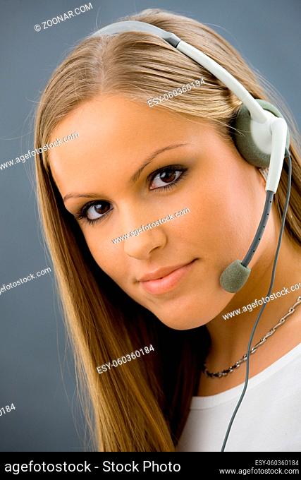 Studio portrait of young female customer service operator talking on headset. Isolated