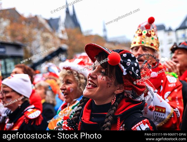 11 November 2023, Colonia: Carnival-goers celebrate the start of the carnival season on Cologne's Heumarkt square. Photo: Oliver Berg/dpa