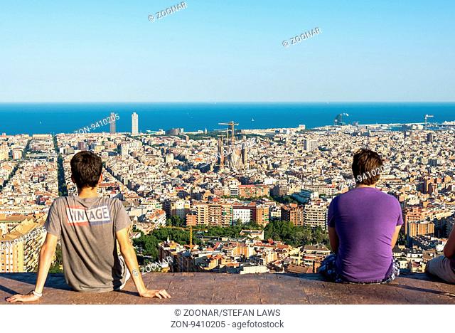 Young people on top the Park Guinardo, one of the west side hills in Barcelona, watching the skyline of Barcelona. From here you have a fantastic overview to...