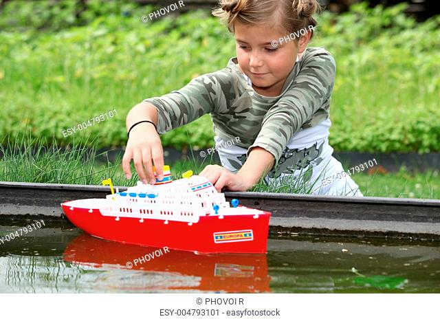 schoolgirl playing with plastic boat