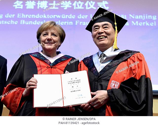 German Chancellor Angela Merkel (L) receives an honorary doctorate from the University of Nanjing from laudator, professor Chen Jun (R)