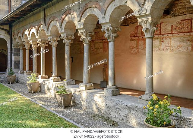 detail of mullions and arches at Romanesque cloister of Abbey on shore of Lario lake, shot in bright fall light at Piona, Lecco, Italy
