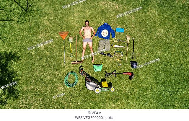View from above of a gardener in laying on the grass with all the tools he need for take care of garden