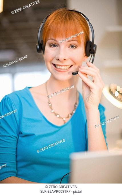 Businesswoman in headset using laptop