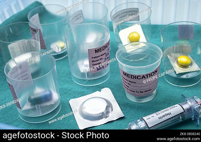Diverse medication in glasses monodose along with heparin injectors in hospital, conceptual image